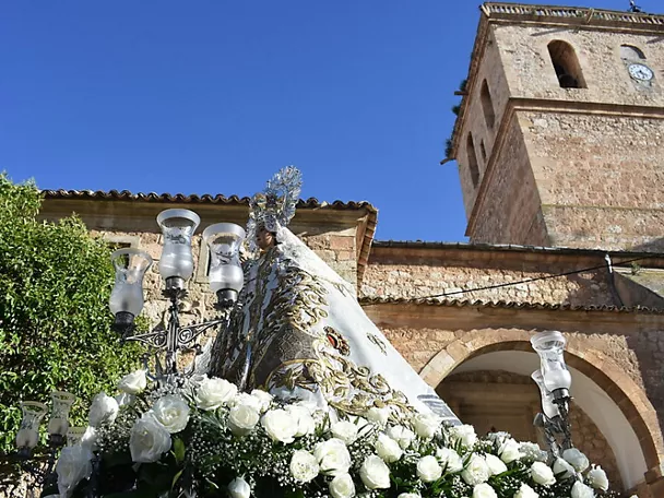 Imagen religiosa con flores blancas ante una iglesia