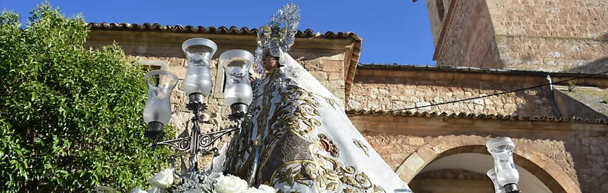 Imagen religiosa con flores blancas ante una iglesia