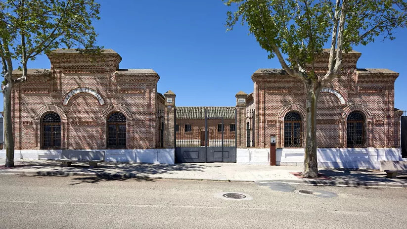 Entrada de ladrillo a un antiguo recinto con rejas