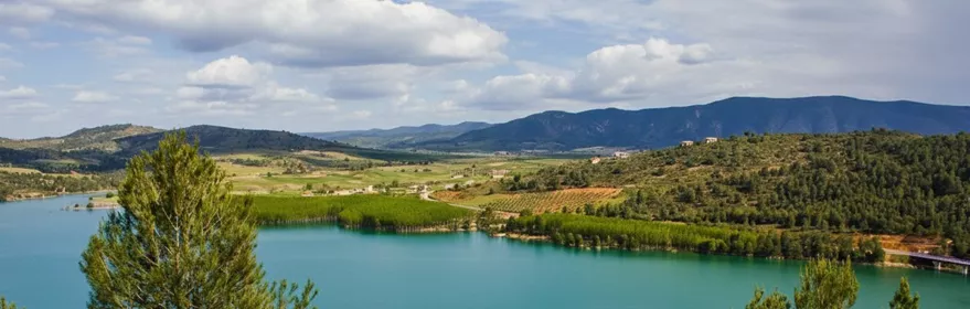 Lago de aguas turquesas rodeado de pinares y montañas