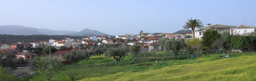 Vista del pueblo entre prados verdes y casas blancas