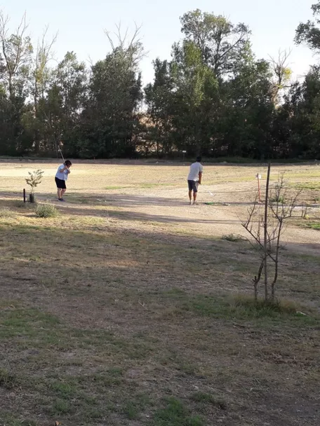 Campo de golf rústico con jugadores al aire libre