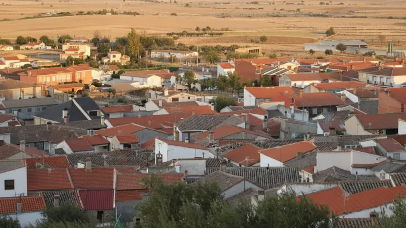 Vista elevada de casas y tejados entre campos