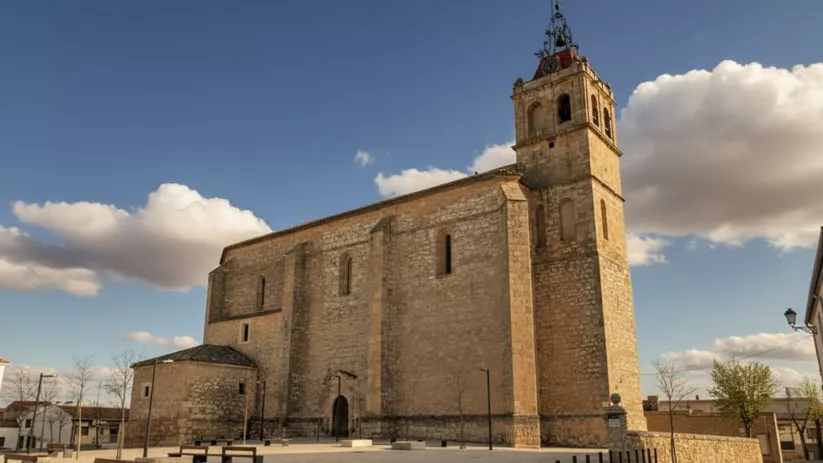 Iglesia de piedra con torre y espacio abierto alrededor