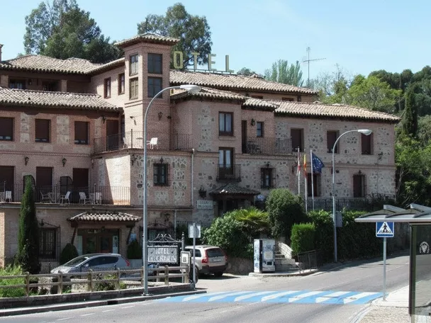 Vista amplia de edificio hotelero tradicional junto a una carretera.