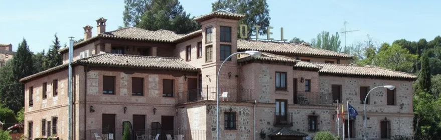 Vista amplia de edificio hotelero tradicional junto a una carretera.