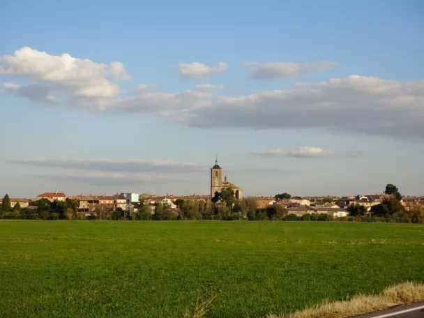 Panorámica del pueblo con campo verde y cielo nublado