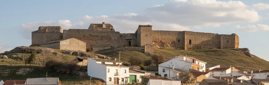 Casas blancas al pie de una fortaleza en lo alto del cerro
