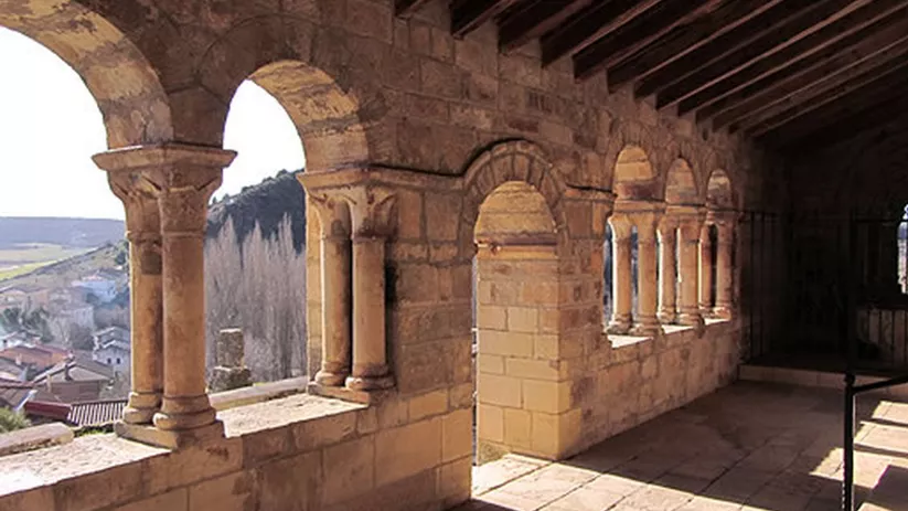 Pasillo porticado con columnas románicas y cubierta de madera