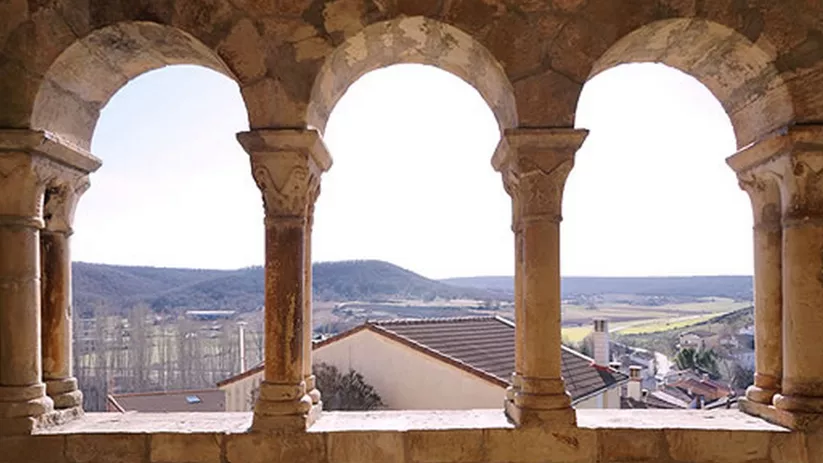 Galería porticada de piedra con arcos y vistas al entorno