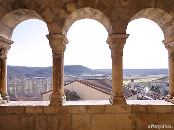 Galería porticada de piedra con arcos y vistas al entorno