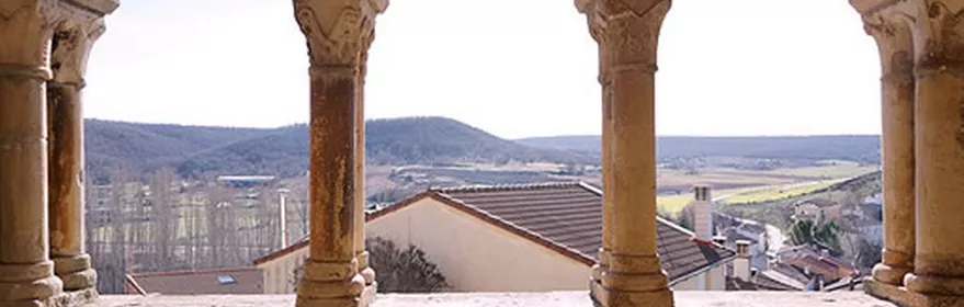 Galería porticada de piedra con arcos y vistas al entorno
