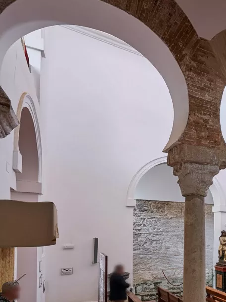 Nave con arcos de herradura y bancos de madera.