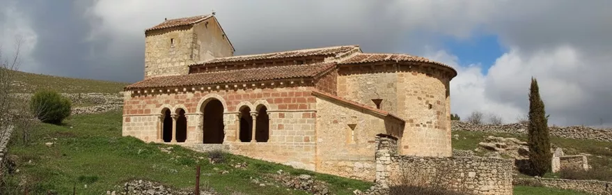 Iglesia románica de piedra en colina.