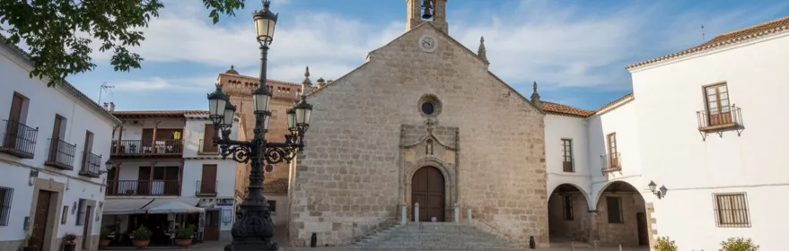Plaza con farola ornamental y fachada de iglesia al fondo.