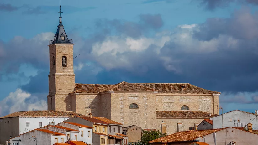 Iglesia de piedra con torre campanario vista desde el casco urbano