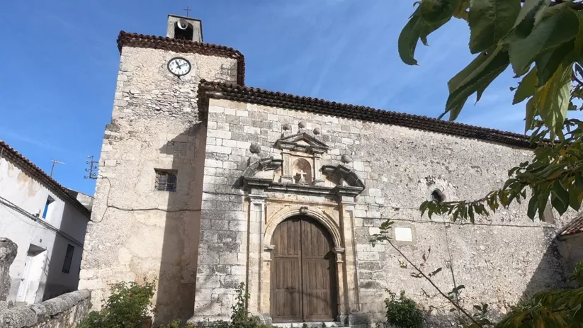Fachada de iglesia de piedra con torre y portada monumental.