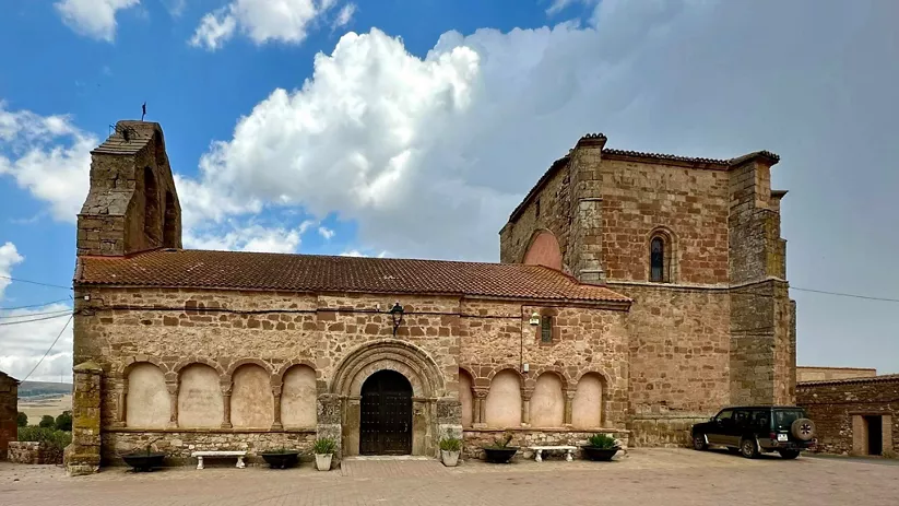 Iglesia románica de piedra en entorno rural.
