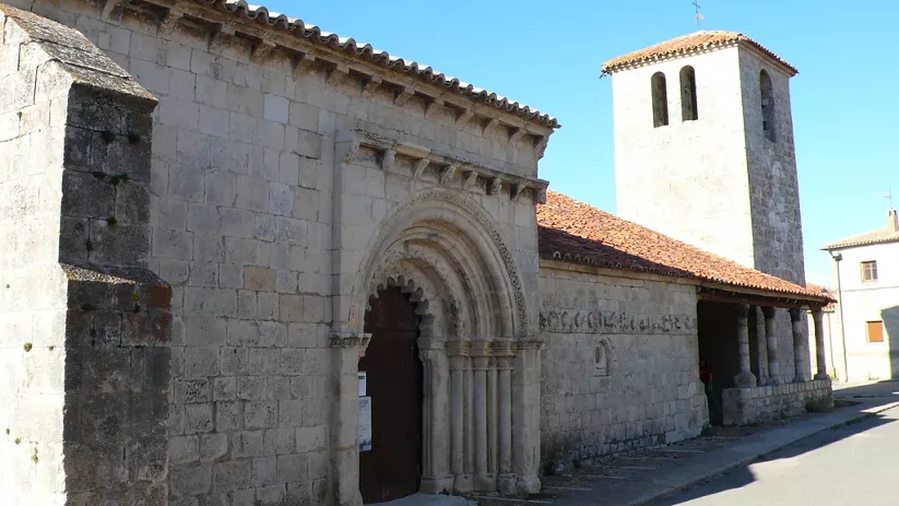 Vista exterior de iglesia románica con torre campanario.