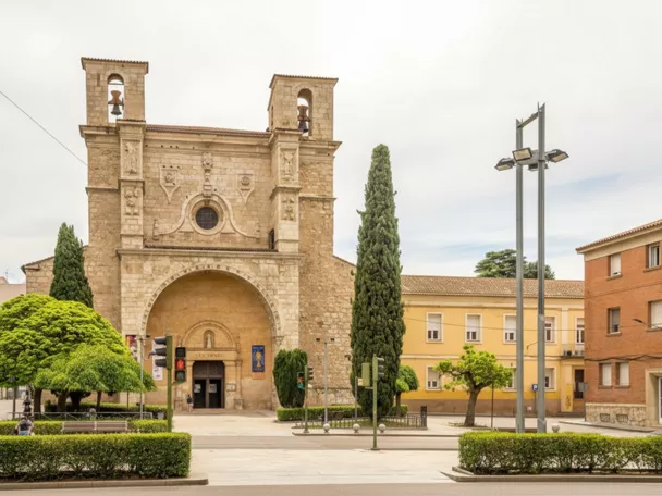 Fachada de iglesia con arco monumental y espadañas.