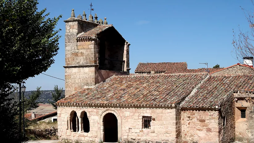 Templo rural de mampostería con tejado de teja curva.