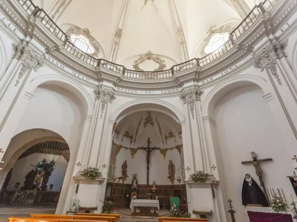 Interior de iglesia con bóveda blanca y altar central.
