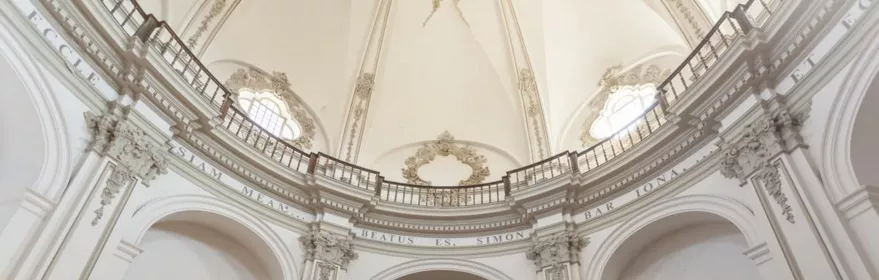 Interior de iglesia con bóveda blanca y altar central.
