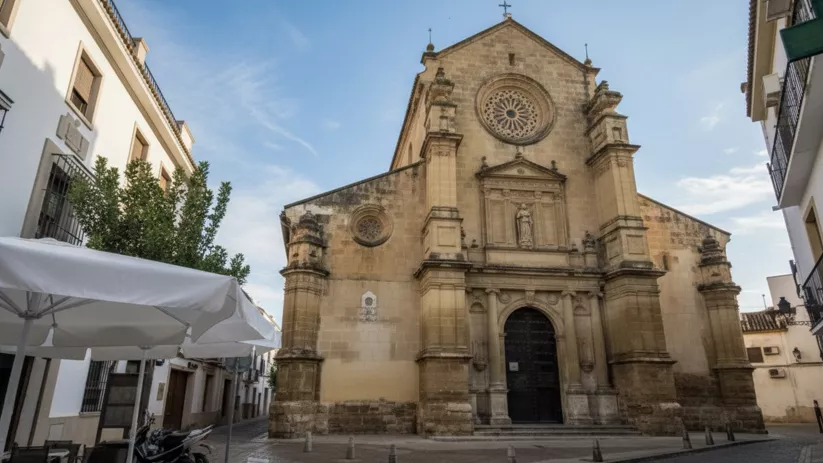 Iglesia de piedra vista desde una plaza con terraza exterior.
