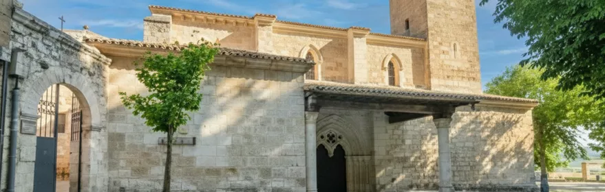 Iglesia de piedra con torre cuadrada y pórtico.