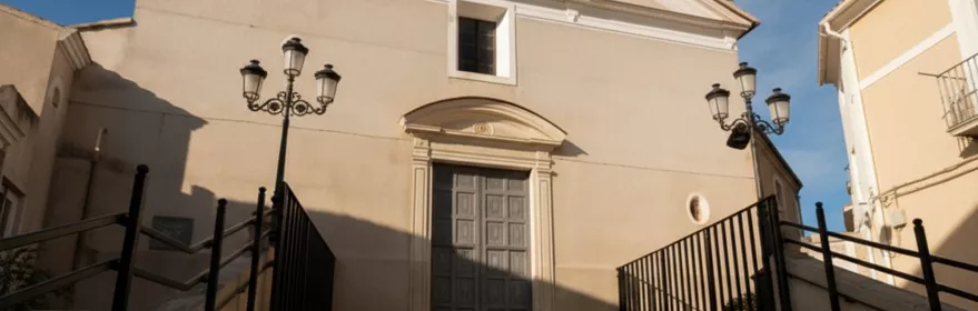 Entrada principal con escalinata, barandillas y fachada clara.