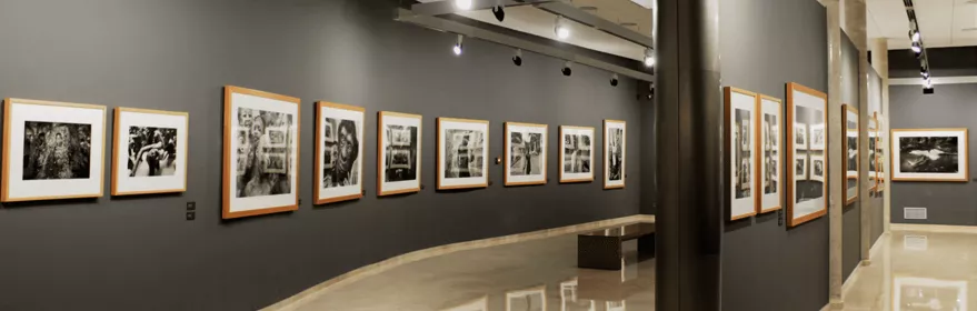 Sala de exposiciones con fotografías enmarcadas y paredes grises