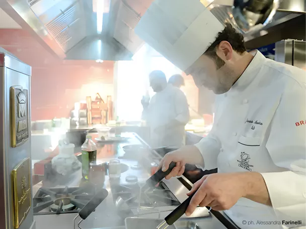 Cocinero trabajando entre vapor en una cocina profesional