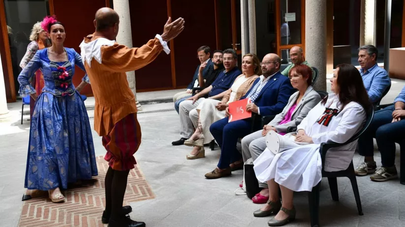 Escena teatral al aire libre con intérpretes caracterizados frente a espectadores.