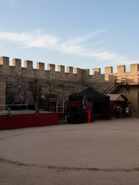 Patio interior de fortaleza con escenario y gradas temporales.
