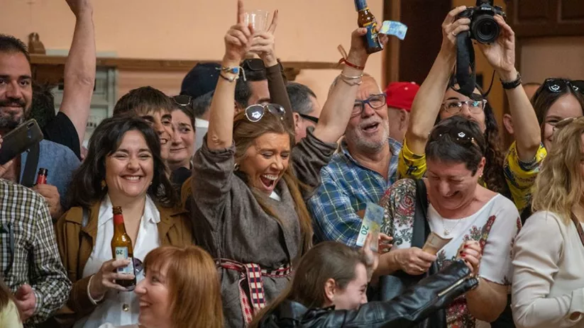 Personas celebrando con bebidas en interior festivo