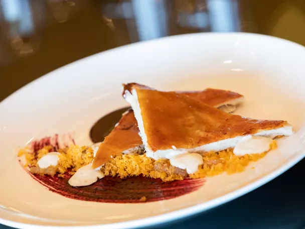 Plato de hojaldre dorado con crema y salsa