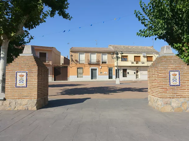 Entrada a plaza entre pilares de ladrillo