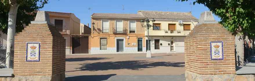Entrada a plaza entre pilares de ladrillo