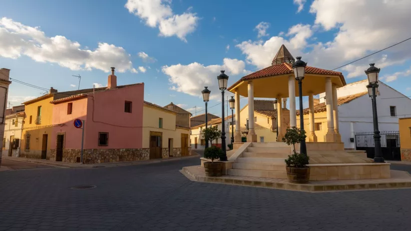 Plaza principal de La Herrera con quiosco central y casas tradicionales de fachadas coloridas bajo un cielo azul.