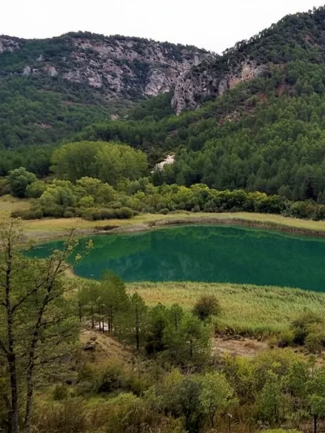 Laguna verde rodeada de montañas.