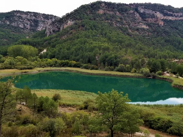 Laguna verde rodeada de montañas.