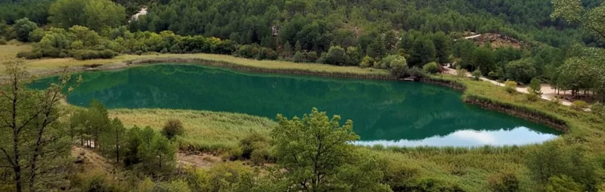 Laguna verde rodeada de montañas.