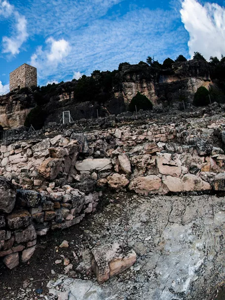 Ruinas de piedra con torre sobre acantilado