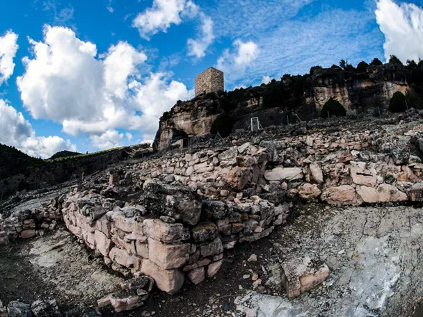 Ruinas de piedra con torre sobre acantilado