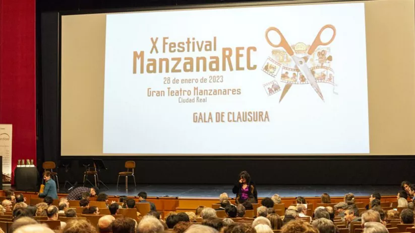 Público sentado frente a una pantalla durante una gala cultural
