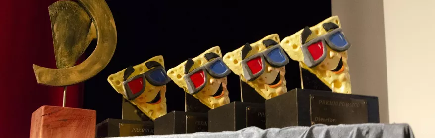 Trofeos artísticos alineados sobre una mesa en un escenario