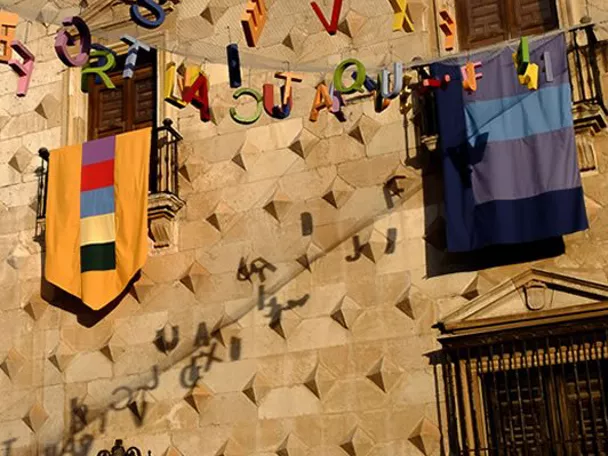 Fachada histórica decorada con banderas y guirnaldas.