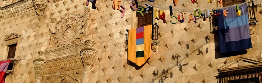 Fachada histórica decorada con banderas y guirnaldas.