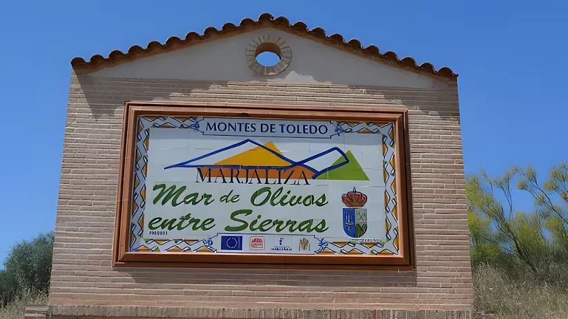 Panel cerámico de bienvenida sobre muro de ladrillo