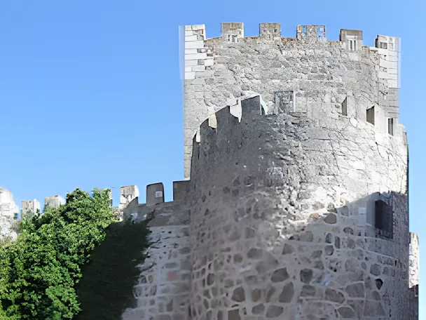 Murallas y torre de castillo junto a edificio histórico